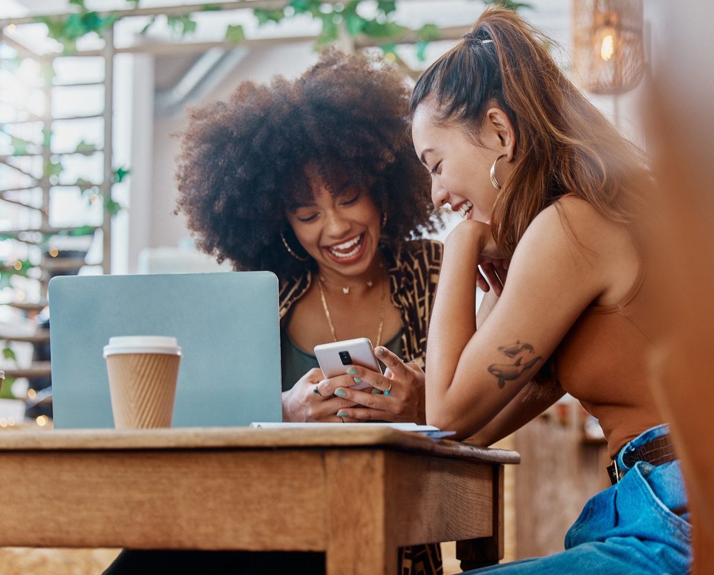 Friends laughing together over coffee at a local cafe