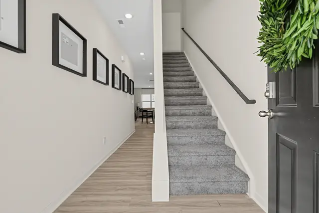 Maywood foyer with staircase and hallway leading to the living area