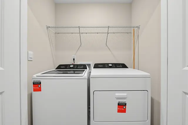 Maywood upstairs laundry with washer, dryer, and shelving