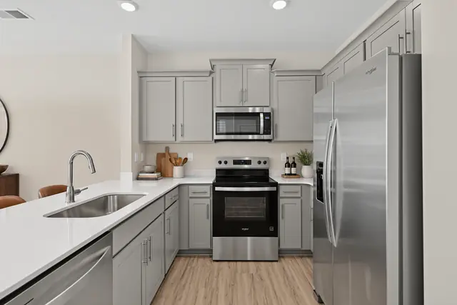 Pearson kitchen with gray cabinets, stainless range, microwave, and refrigerator