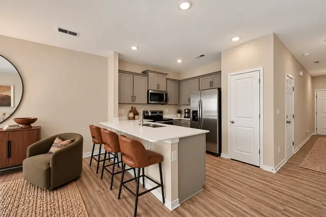 Pearson kitchen island with leather bar stools and stainless appliances