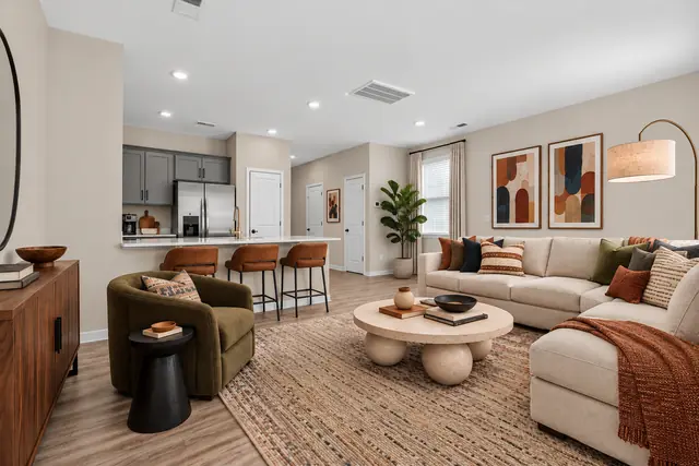 Pearson living room with sectional sofa and lounge chair open to the kitchen