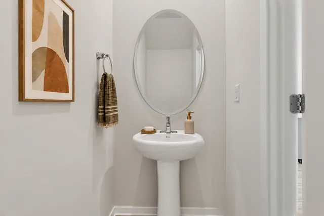 Pearson powder room with pedestal sink and oval mirror